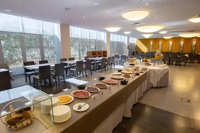 a buffet line with plates of food in a restaurant at Hotel Ciudad de Ponferrada, Ascend Hotel Collection in Ponferrada