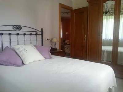 a bedroom with a bed with purple and white pillows at Vivienda de Uso Turístico Carballo Blanco 2 in Barral