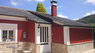 a red and white house with a table at Vivienda de Uso Turístico Carballo Blanco 2 in Barral