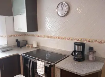 a kitchen with a sink and a clock on the wall at Vivienda de Uso Turístico Carballo Blanco 1 in Barral