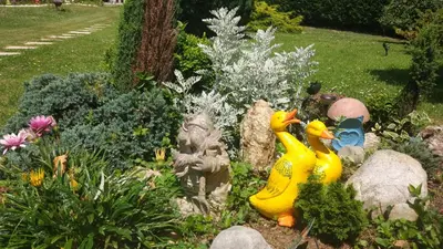 two rubber ducks in a garden with rocks and flowers at Vivienda de Uso Turístico Carballo Blanco 1 in Barral