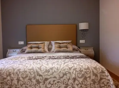 a bedroom with a large bed with a large headboard at Vivienda de Uso Turístico Carballo Blanco 1 in Barral