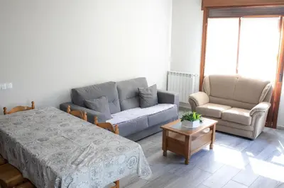a living room with a bed and a couch and a chair at Casa Rural Las Mestas in Cangas del Narcea