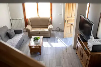 a living room with a couch and a television at Casa Rural Las Mestas in Cangas del Narcea