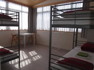 a room with three bunk beds and a table at O Cabalo Verde in Palas de Rei
