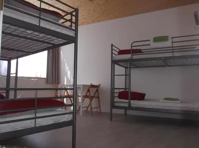a room with three bunk beds and a chair at O Cabalo Verde in Palas de Rei
