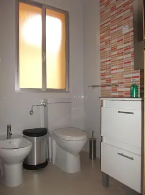 a white bathroom with a toilet and a sink at O Cabalo Verde in Palas de Rei