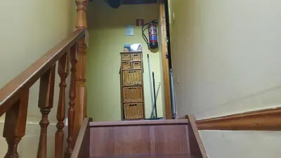a hallway with a stairway with a refrigerator at A Palleira in Castro Caldelas