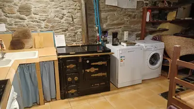 a kitchen with a sink and a washing machine at A Palleira in Castro Caldelas