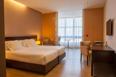 a hotel room with a large bed and a desk at Hotel San Miguel in Santiago de Compostela