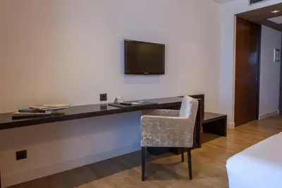a desk with a chair and a television on a wall at Hotel San Miguel in Santiago de Compostela