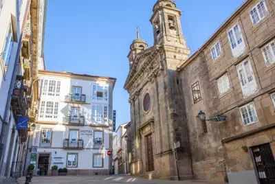 an old building with a clock tower on a street at Hotel San Miguel in Santiago de Compostela