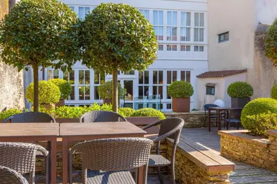 a patio with tables and chairs and a building at Hotel San Miguel in Santiago de Compostela