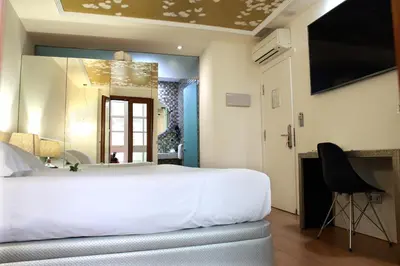 a bedroom with a white bed and a desk and a mirror at Casas Reais Boutique in Santiago de Compostela