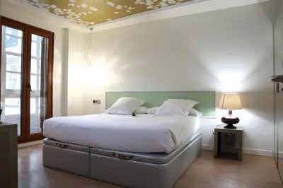 a bedroom with a bed and a tv on the wall at Casas Reais Boutique in Santiago de Compostela