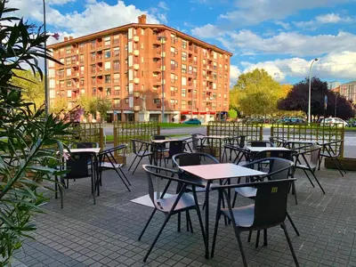 a group of tables and chairs in front of a building at Hostal RIO SELMO in Ponferrada