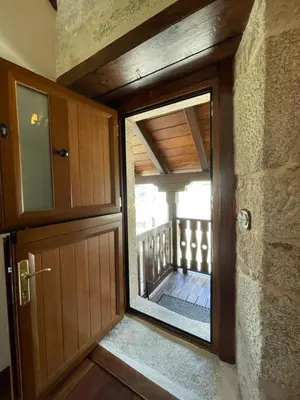 a door with a window in a room with a balcony at Casa Casoa in Piornedo