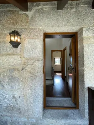 a hallway with a mirror on a stone wall at Casa Casoa in Piornedo