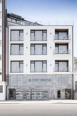 a white building with a sign on the side of it at Apartahotel A Cetárea in Burela de Cabo