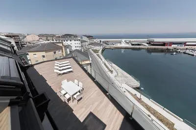 a view of a patio with chairs and a swimming pool at Apartahotel A Cetárea in Burela de Cabo