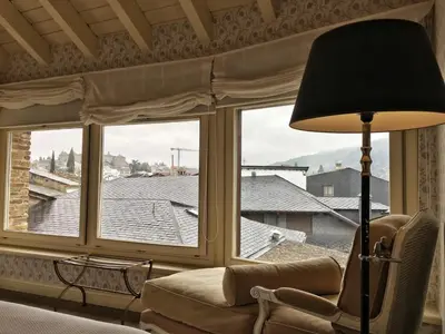a living room with a couch and a large window at Las Doñas del Portazgo in Villafranca del Bierzo