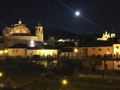 a view of a city at night with the moon at Las Doñas del Portazgo in Villafranca del Bierzo