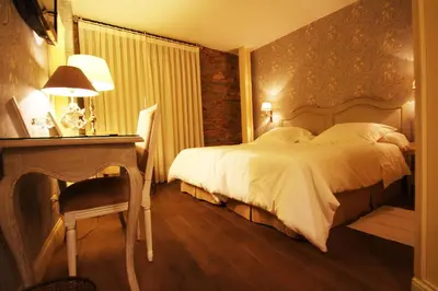 a hotel room with a bed and a table and a fireplace at Las Doñas del Portazgo in Villafranca del Bierzo