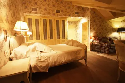 a bedroom with a white bed and a couch at Las Doñas del Portazgo in Villafranca del Bierzo