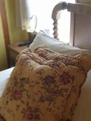 a bed with a flower patterned blanket on it at La Casina de Terobe in Cacabelos