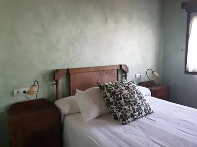 a bed with a black and white pillow on it at La Casina de Terobe in Cacabelos