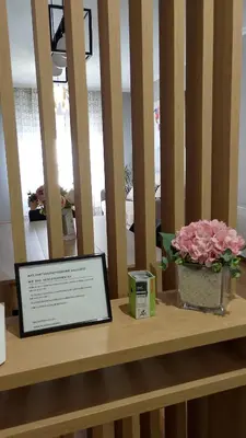 a table with a vase of pink flowers on a shelf at REGO DA RAÑA APARTMENTS in Arzúa