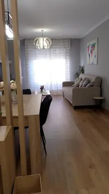 a living room with a table and a couch at REGO DA RAÑA APARTMENTS in Arzúa