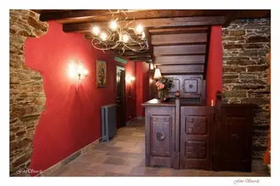 a hallway with a red wall and a chandelier at Casa Rural Vila Pomar in Ribadeo