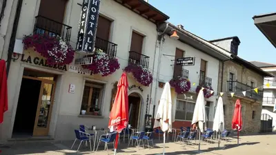 a group of umbrellas and chairs in front of a building at La Gallega in Cacabelos