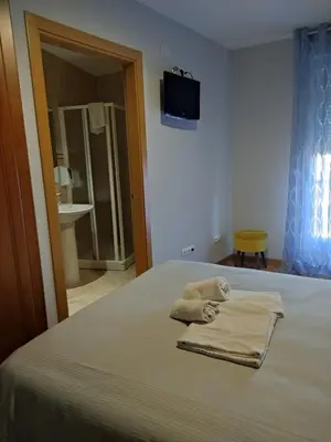 a bedroom with a bed with towels on it at La Gallega in Cacabelos