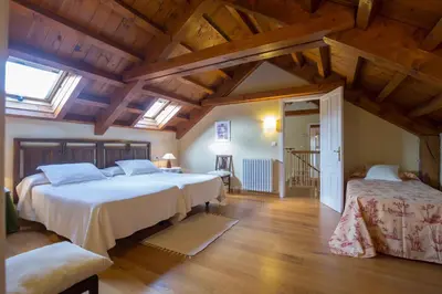 a bedroom with two beds in a room with wooden ceilings at Casa Rural Graña da Acea in Monfero