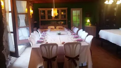 a long table with white chairs in a room at Casa Rural Graña da Acea in Monfero