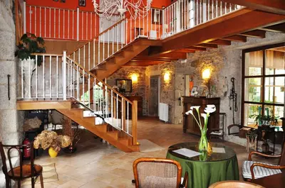 a large room with a staircase and a table at Casa Rural Graña da Acea in Monfero