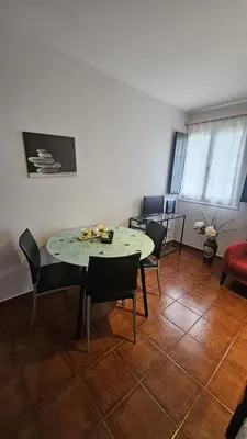 a dining room with a table and chairs and a room at Apartamentos Castello in Cartavio