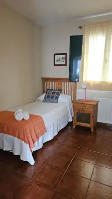 a bedroom with a bed and a table and a window at Apartamentos Castello in Cartavio