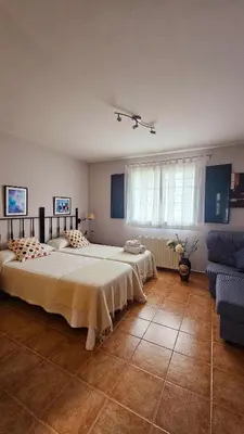 a bedroom with a large bed and a couch at Apartamentos Castello in Cartavio