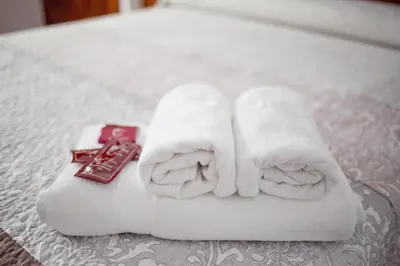 a pile of towels and a remote control on a bed at Hotel Victorino in Silleda