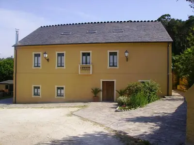 a large yellow house with a driveway at Casa da Roxa in Foz