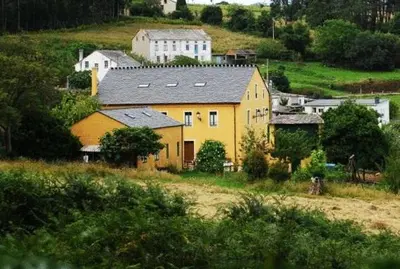 a yellow house on the side of a hill at Casa da Roxa in Foz