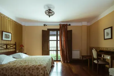 a bedroom with a bed and a desk and a window at El Tiempo Recobrado - Hotel de relax en El Bierzo in Villamartín de la Abadía