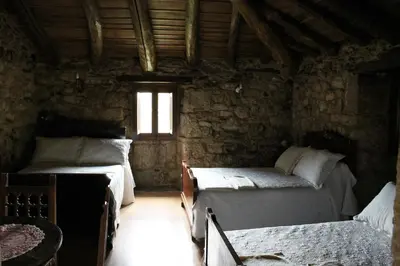 a room with two beds and a window at Casiña de Campo in Ferreiros