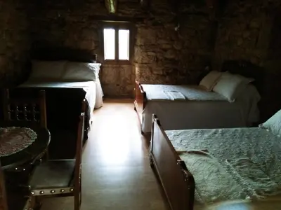 a room with three beds and a window at Casiña de Campo in Ferreiros