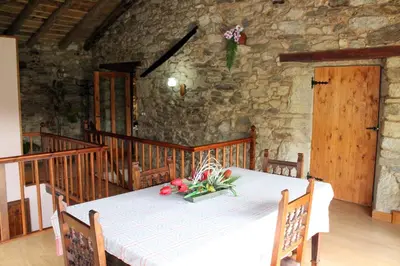 a white table with flowers on it in a room at Casiña de Campo in Ferreiros