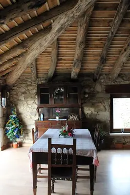 a dining room with a table and chairs in a building at Casiña de Campo in Ferreiros