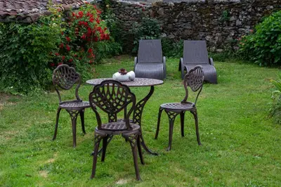 a table with four chairs and a cat sitting on top at Casa Vixide in Lalín